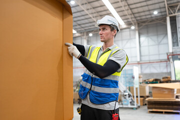 Caucasian foreman or businessman checking Kraft paper stock at warehouse	
