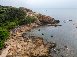 Aerial view of small traditional Vietnamese fishing boats moored in a small bay surrounded by rocks on the South China Sea in Vietnam's Phu Yen province
