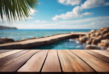 Tropical beach view from wooden deck with palm leaves, clear sky, and jetty over turquoise sea.