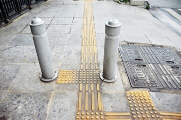 The yellow rough textured floor installed in the pedestrian area and intended for people with...