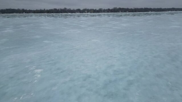 A low 4K drone shot showing a frozen Lake Simcoe in Ontario Canada. Large crack visible.