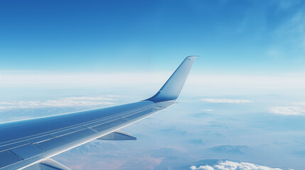 Obraz premium Airplane wing with blue sky and clouds in view