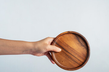 Wooden plate in hand on white background.