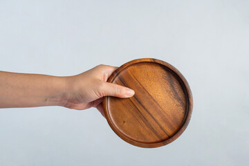Wooden plate in hand on white background.