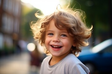 Portrait of a cute little boy with blond curly hair outdoors.