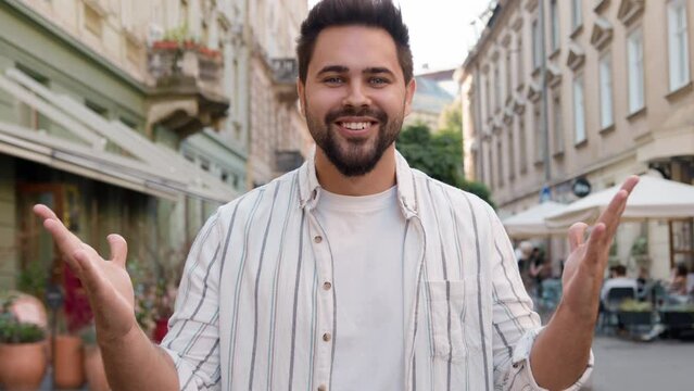 Young Caucasian European man rejoice gesturing smiling victory success good luck shouting yes hurray city street outdoors enjoying delight happy guy amazed excited emotional male joyful astonishment