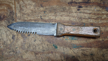 Hori-hori Japanese gardening knife on a distressed wood work area top