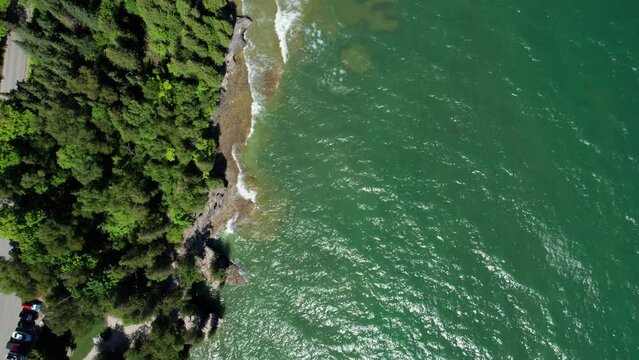 Drone aerial view looking straight down on waves crashing on the shoreline