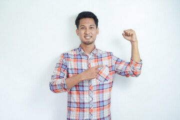 Fototapeta premium Adult Asian man smiling while pointing to his bicep muscle