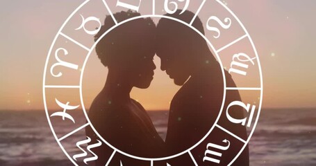 Animation of horoscope moving over happy biracial couple embracing at beach - Powered by Adobe