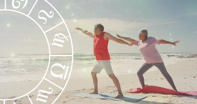 Animation of horoscope moving over happy senior biracial couple practicing yoga at beach