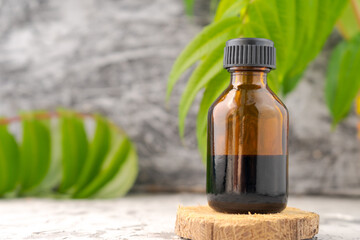 A bottle essential oil is sitting on a wooden surface