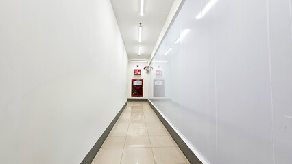 Long white corridor with Fire extinguisher. Empty modern bright corridor. Fire Extinguishers for...