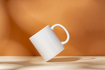 White ceramic mug on peach background with shadows