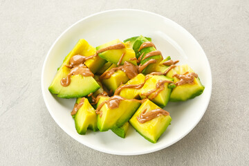 Avocado with almond butter served in white plate
