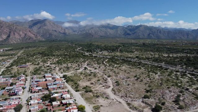 Flyover pulls back from Cafayate town in mtn plateau of Argentina