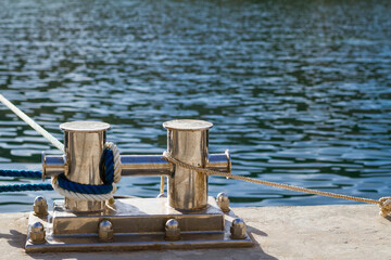 A pair metal anchors are tied to rope in water