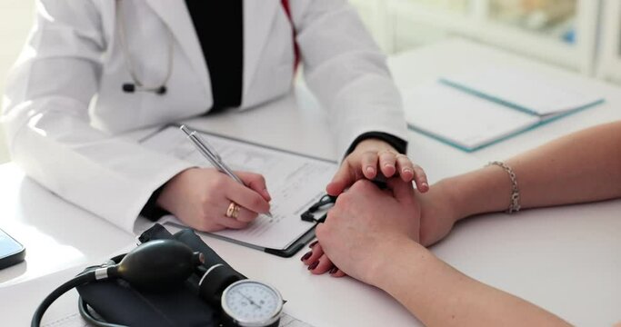 Lady physician writes treatment plan on paper for patient
