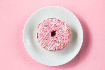 a pink donut on a plate