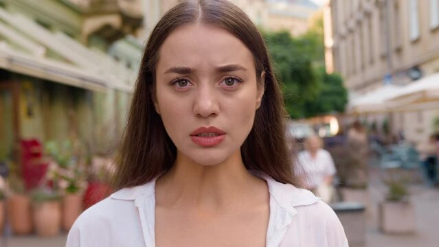 Close up Caucasian unhappy girl street city annoyed woman frowning emotions displeased disappointed dissatisfied angry female envy irritation bad reaction serious expression confident negative pensive