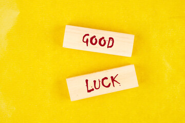 GOOD LUCK symbol on wooden blocks on a yellow background