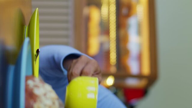 Person holding yellow object for pet parrot in electric blue room
