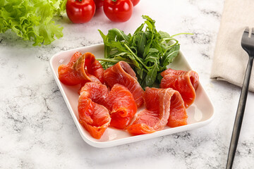 Sliced salmon with fresh arugula