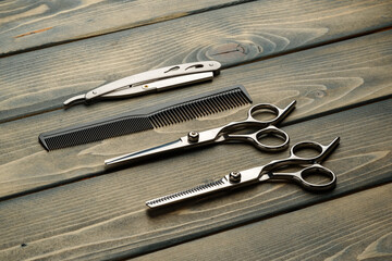 Hairdressing professional scissors on wooden background close up