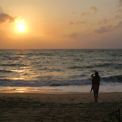 Fototapeta na wymiar Yoga at sunrise on the beach on the island