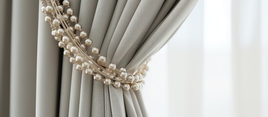 Gray drapes enhanced with a natural beaded curtain tie back