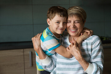 grandmother and kid grandson hug and spend time together at home
