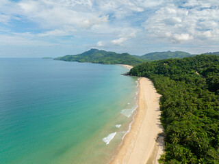 Mariposa Beach with ocean waves on sands and turquoise sea water. El Nido, Philippines.