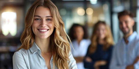 Fototapeta premium Portrait of a smiling businesswoman with colleagues in the background at office, team leader