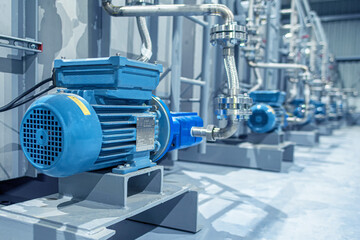 Industrial equipment. New blue electric motors with pumps on the stainless steel production line. Industrial background. Additive pump station in petrochemical technology.