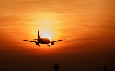 Fototapeta na wymiar Flugzeug fliegt dem Sonnenuntergang entgegen