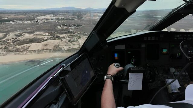 Real time cockpit scene. White Captain european piloting an airplane approaching to Alicante Airport, in the Mediterranean Sea coast. Spain. Immersive pilot FPV POV. 4K