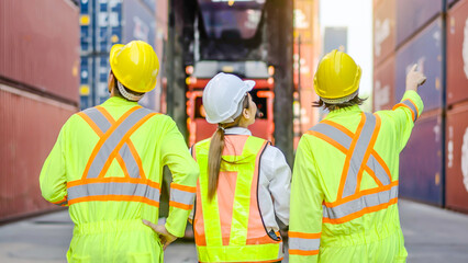 Back of group professional dock worker and engineering people walking and taking with their supervisor while record data online with digital connection tablet, background of crane and layer of tank