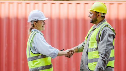 Happy dealing shaking hands two foreman worker working checking at container cargo harbor to loading containers, engineer man having hand shack with his woman boss after work discussion