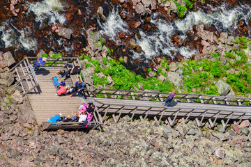 Hikers resting on a viewing platform at a river