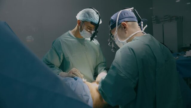 Medical team men doctors surgeons medics processing bariatric surgery stomach belly surgical operation with scalpel illness tumor sore emergency aid treatment hospital clinic health patient medicine