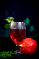 ripe pomegranate and glass of wine on Red background. Background has Flowers