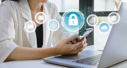 Cyber security technology, data protection concept. Businesswoman using mobile phone and laptop computer with privacy security and data encryption system, secure internet access. 