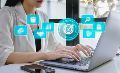 Businesswoman using computer laptop with dartboard for setup business objective target and goal concept.