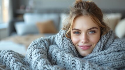 A young woman is wrapped in a cozy blanket