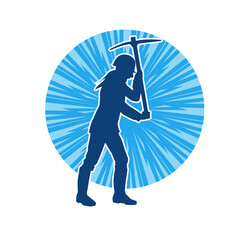 Obraz premium Silhouette of a woman in worker costume carrying pick axe tool in action pose. Silhouette of a female miner in action pose with pick axe tool.