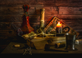 On the table are antique nautical maps, a box, a leather-wrapped bottle and a metal goblet, a smoking pipe and a pocket watch. Burning candle.