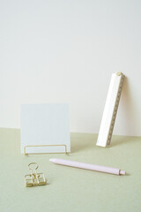 Blank memopad with gold metallic holder, ruler, pen, clip on desk. white ivory background....