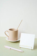 Blank memopad with holder, pen, mug cup on desk. white ivory background. workspace office stationery