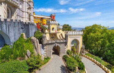 Aerial panoramic exterior and wide view of the colorful Pena Palace with the path up to the arched...