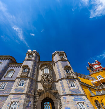 Vista en &aacute;ngulo bajo de la entrada al patio de arcos del Palacio de Pena con la estatua de Trit&oacute;n sobre una concha con talla decorativa de piedra encima del arco. Sintra. Portugal.